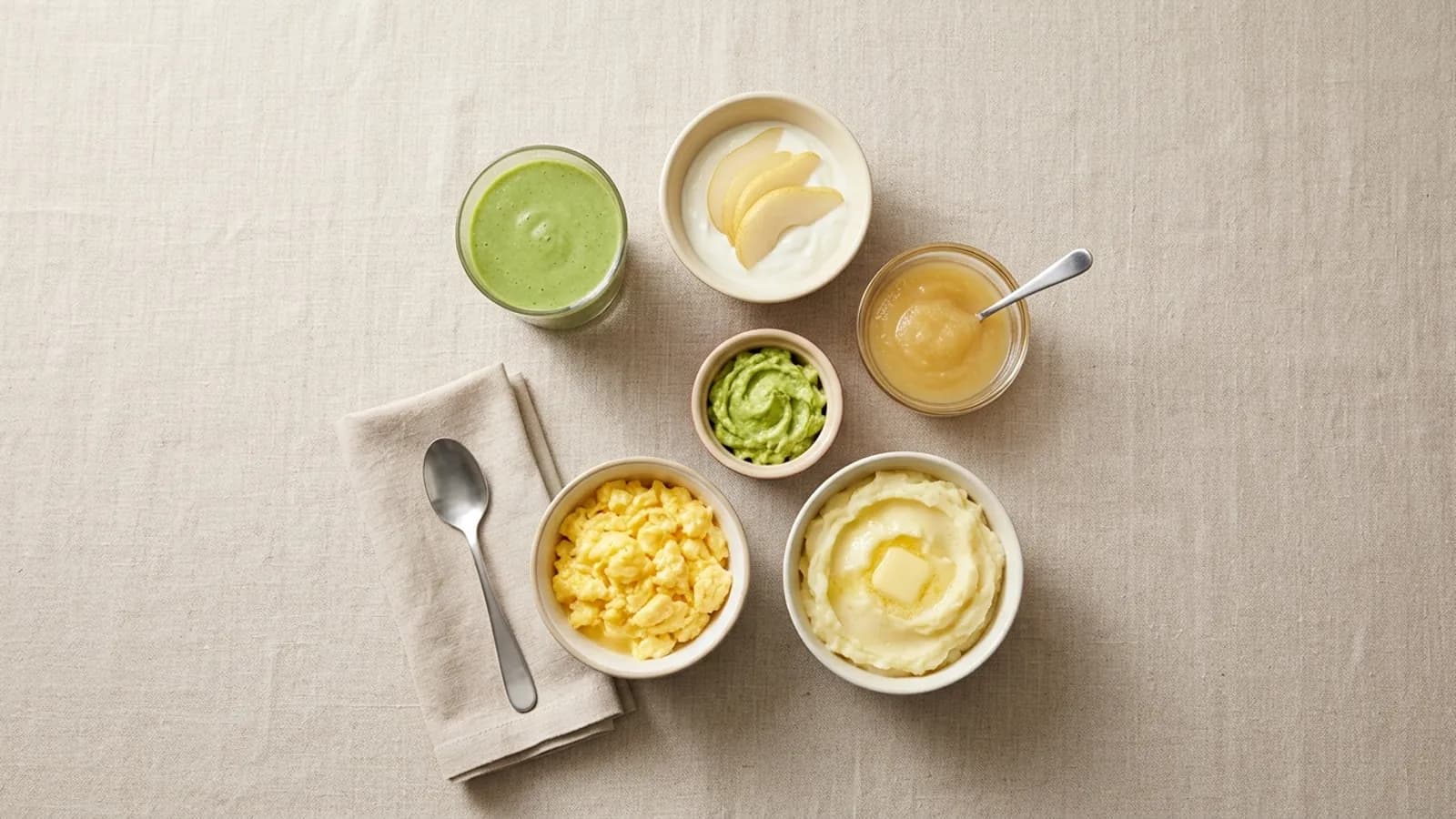 Illustration: soft, cool foods for the first days after an extraction — a green smoothie without a straw, yogurt with pear slices, applesauce, mashed avocado, scrambled eggs and mashed potatoes.