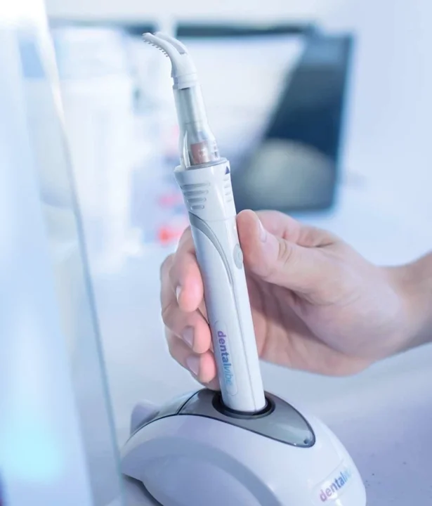 DentalVibe device applying gentle vibration near injection site.