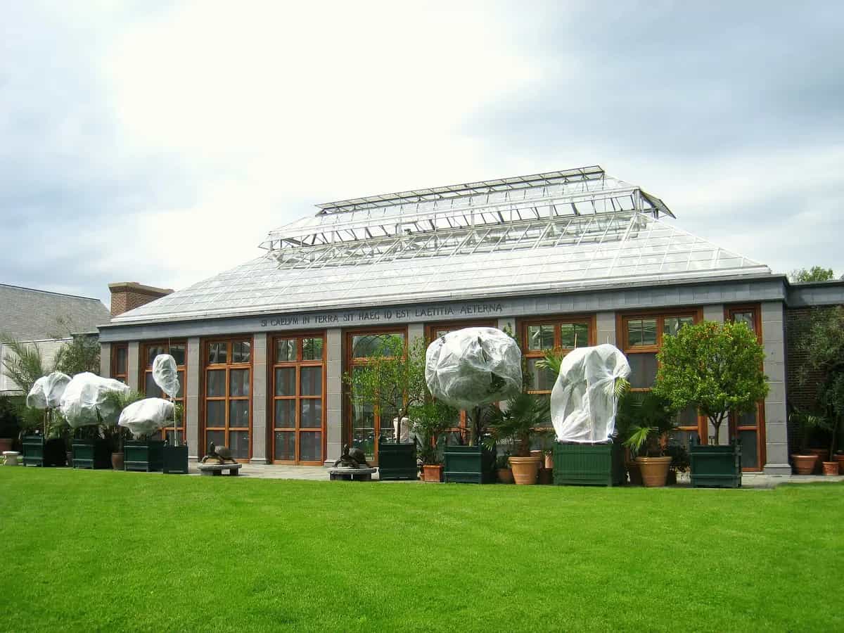 The glass Orangerie conservatory and green lawn at the New England Botanic Garden at Tower Hill in Boylston, Massachusetts